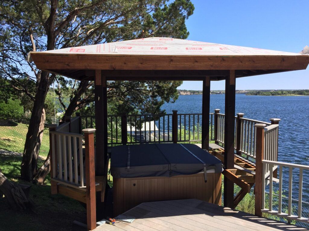 Custom hot tub roof, walk-around decking, and railing during construction.